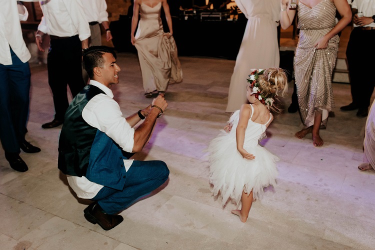 groom and flower girl dancing at reception