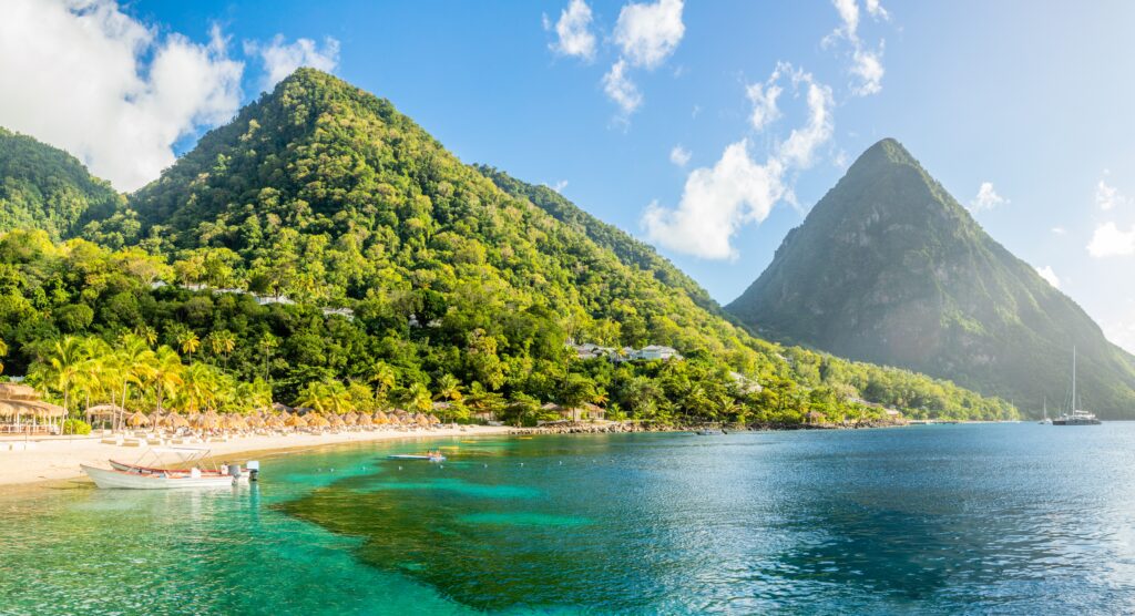 Caribbean,Beach,With,Palms,And,Straw,Umrellas,On,The,Shore